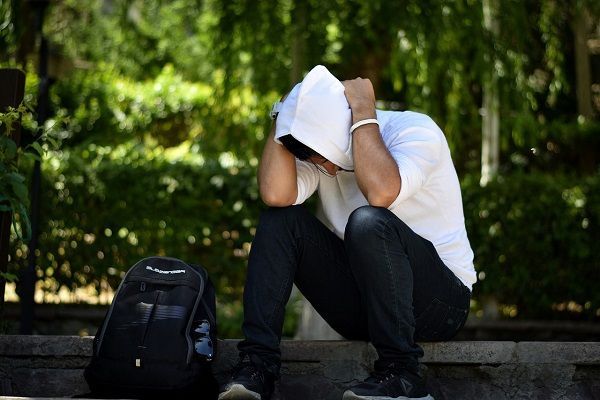 uomo giovane molto triste perché non sa se rivolgersi ad uno specialista per trattare la caduta dei capelli
