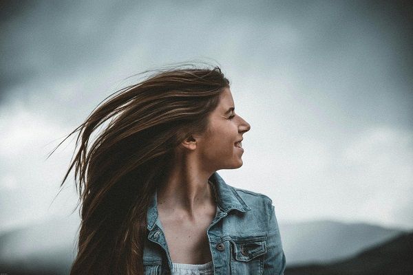 una donna con gli occhi rivolti da un lato e i lunghi capelli castani