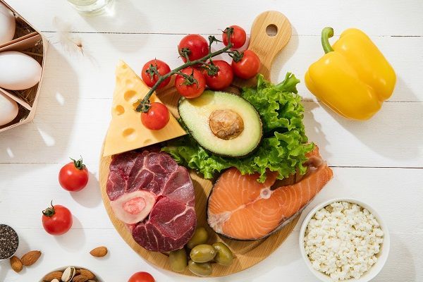 Dieta chetogenica a basso contenuto di carboidrati - selezione di alimenti su sfondo bianco in legno. Ingredienti organici sani ed equilibrati ad alto contenuto di grassi. Nutrizione per il cuore e i vasi sanguigni. Carne, pesce e verdure.