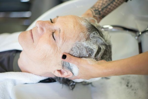 donna che si sta lavando i capelli con uno shampoo speciale