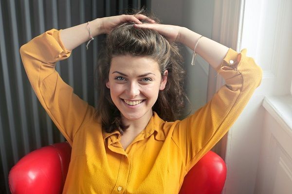 giovane donna con una camicia gialla che si ha appena lavato i capelli