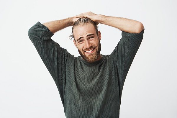 Ritratto di uomo maturo e bello che guarda la tv dopo il lavoro a casa, essendo sconvolto 