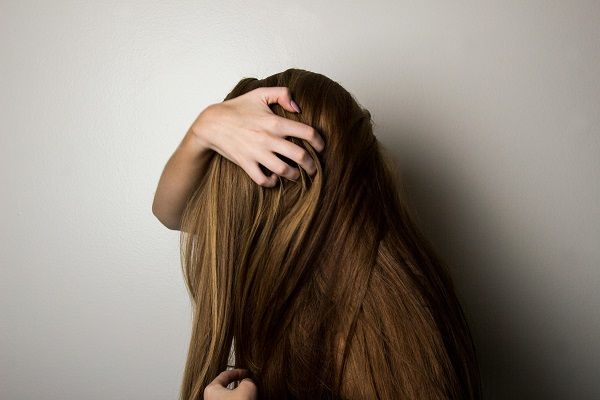 donna che si pettina i capelli con le mani