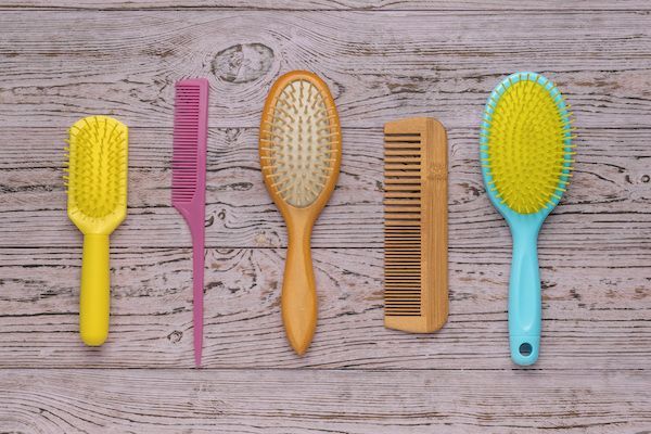 una serie di spazzole per capelli di diverso colore e materiale