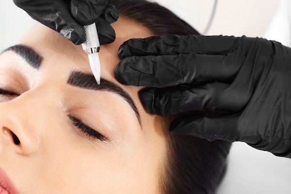 giovane donna che riceve un trattamento professionale per le sopracciglia nanoblading