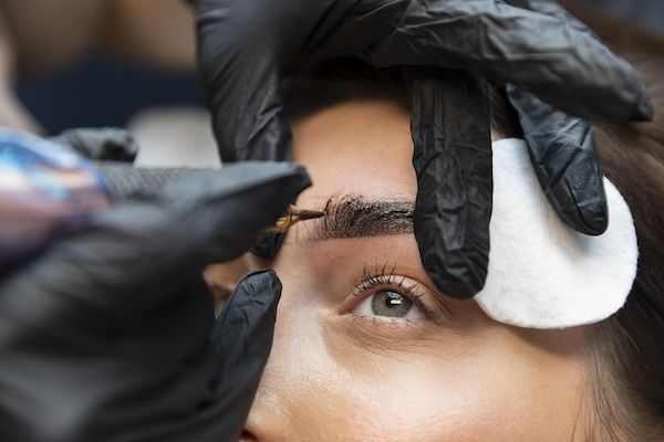 donna che riceve un trattamento per le sopracciglia da una professionista