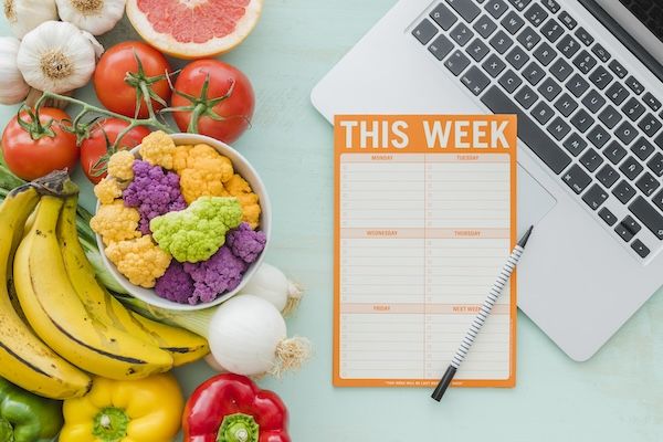 Piano dietetico settimanale e verdure salutari sullo sfondo