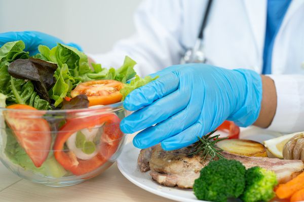 nutrizionista con cibo salutare petto di pollo insalata
