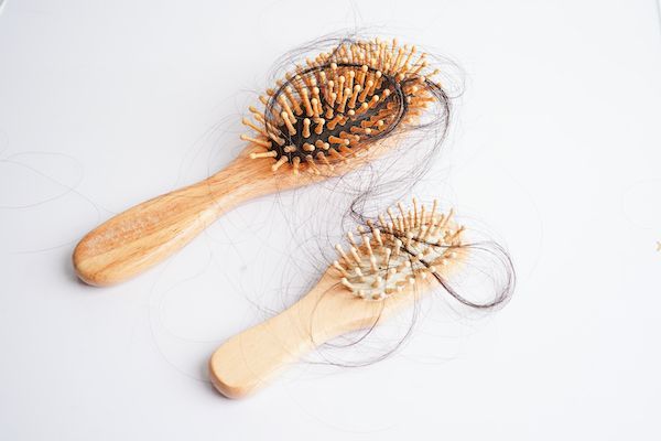 due spazzole di bamboo per capelli con segni di alopecia