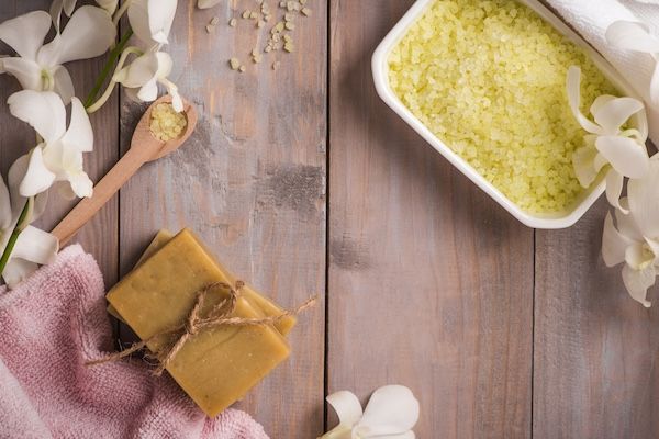 Set da spa. Sapone naturale biologico fatto a mano e orchidea bianca su uno sfondo di legno.