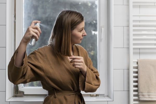 Vista laterale della giovane donna sorridente e felice con capelli lisci e brillanti.