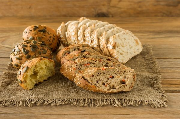 Assortimento di pane fatto in casa su un rustico tavolo di legno. Panetteria casereccia al forno.