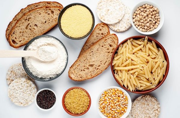 Alimenti carboidrati su un tavolo bianco.