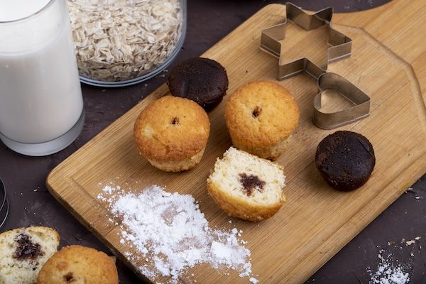 Vista laterale di muffin al cioccolato su un tagliere di legno