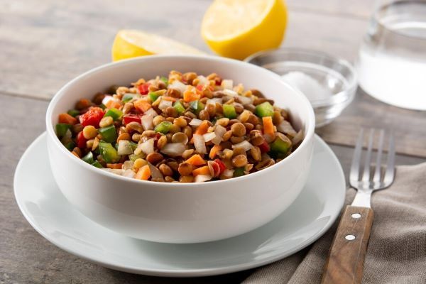 Piatto di lenticchie con paprika e carote. Le lenticchie sono un alimento usato raramente ma ricco di fibre e minerali.