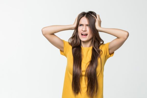 La ragazza tiene i capelli preoccupati con entrambe le mani.