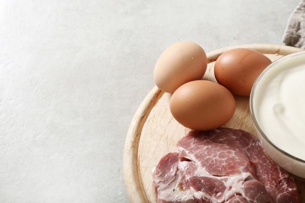 Tagli di carne e uova su una tavola di legno.