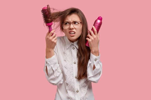 Donna frustrata e insoddisfatta dei suoi capelli. I prodotti chimici di bellezza e l'usura spesso rendono i capelli opachi.