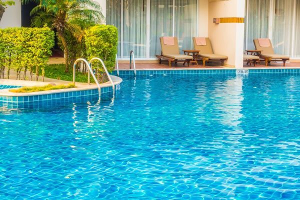 Piscina con sedie in una giornata di sole.