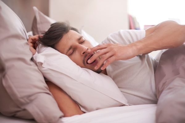 Ragazzo che sbadiglia nel suo letto