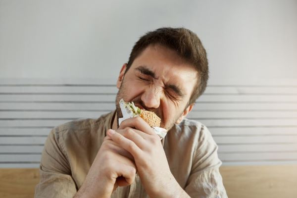 Il ragazzo morde un panino