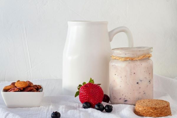 Contenitori di yogurt con noci e frutti di bosco.