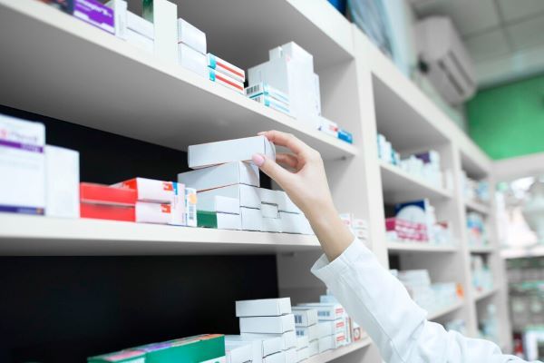 Persona che afferra una scatola di medicinali.