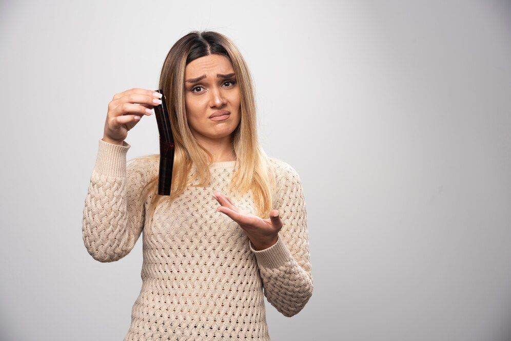 Ragazza scontenta che tiene una ciocca di capelli.