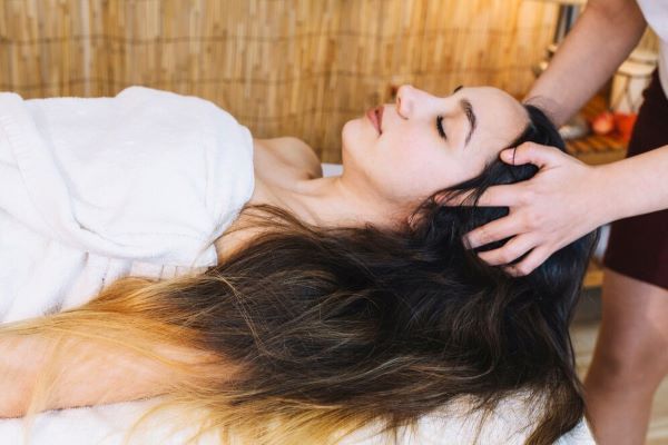 Ragazza che riceve un massaggio al cuoio capelluto