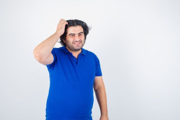 Un uomo con la mano tra i capelli