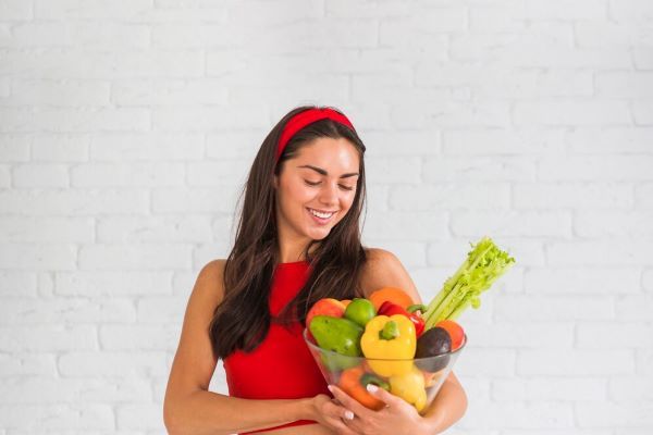 Ragazza che tiene una ciotola con le verdure