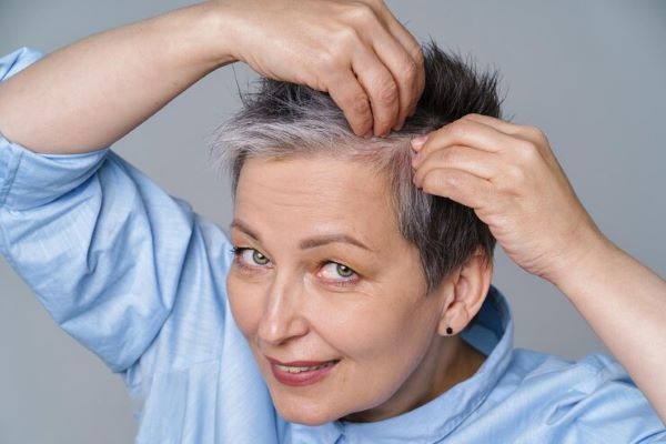 Signora che si controlla i capelli