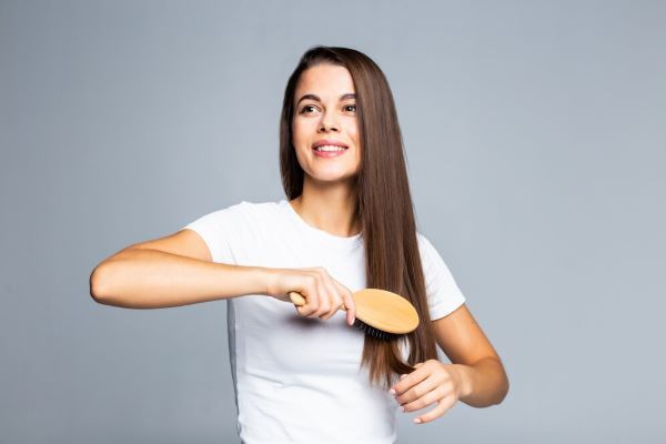 Ragazza felice che si pettina i capelli
