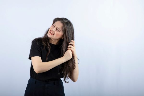 Donna a disagio a causa della sensazione tra i capelli