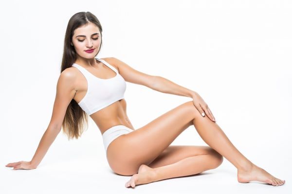 Ragazza seduta sul pavimento in biancheria intima bianca