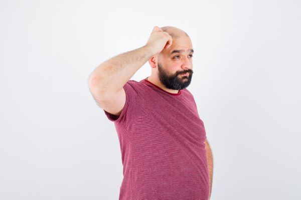 Uomo con le mani sulla testa come se avesse un dubbio