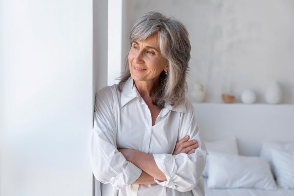 Signora appoggiata alla finestra che guarda fuori