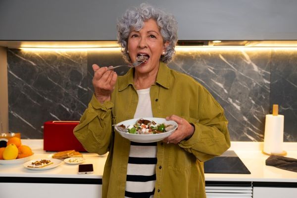 La signora mangia una ciotola di insalata
