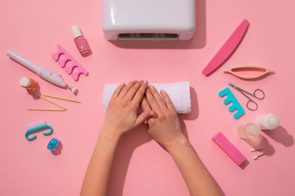 Ragazza circondata da forniture per manicure in casa