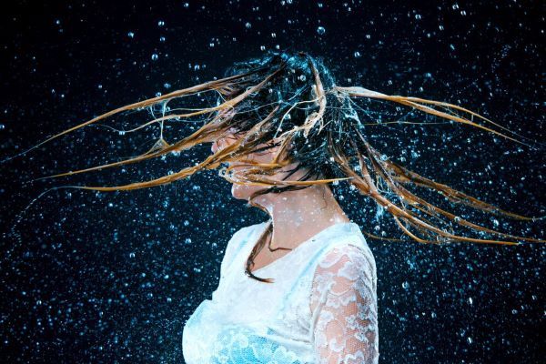 Ragazza che muove i capelli in acqua fredda