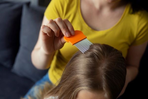 Bambina con i pidocchi sulla testa