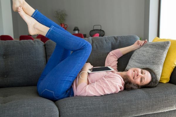 Ragazza con le gambe sollevate sul divano