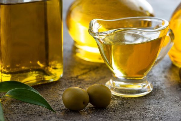 tazza di olio d'oliva con olive verdi