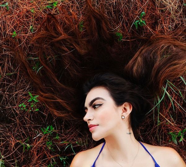 Una bella giovane donna rannicchiata nell'erba.
