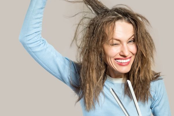 Bella donna con capelli disordinati Parrucchiere Parrucchiere che raddrizza piastre per capelli