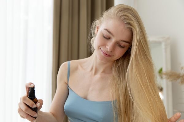 Bella giovane donna con lacca per capelli