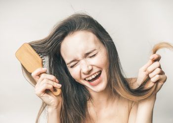 La donna che ride gode della sua bellezza dei capelli, della felice assistenza sanitaria