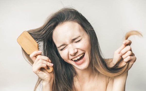 La donna che ride gode della sua bellezza dei capelli, della felice assistenza sanitaria