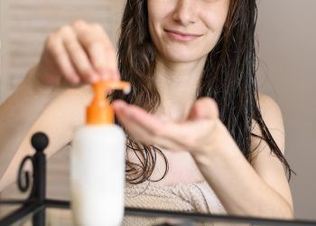 Direttamente sopra il colpo di siero idratante e ramoscello su sfondo bianco