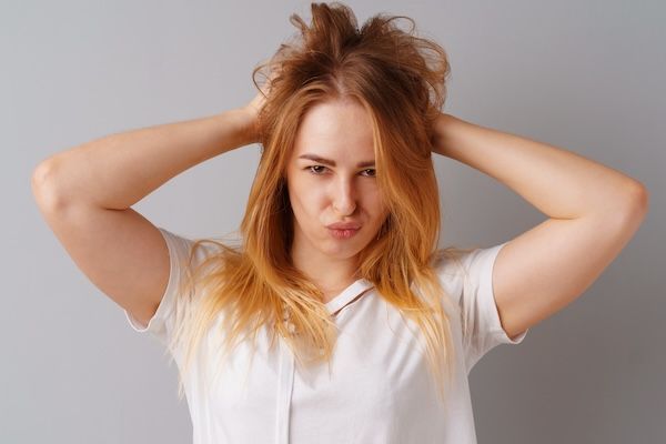 Posa bionda positiva della donna dell'adolescente